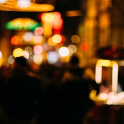Warm street lights and a night crowd, out of focus