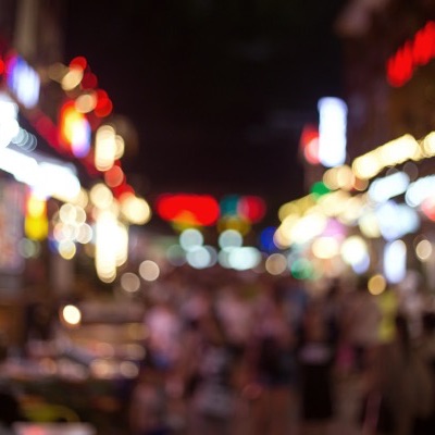 Lit bar street at night, out of focus