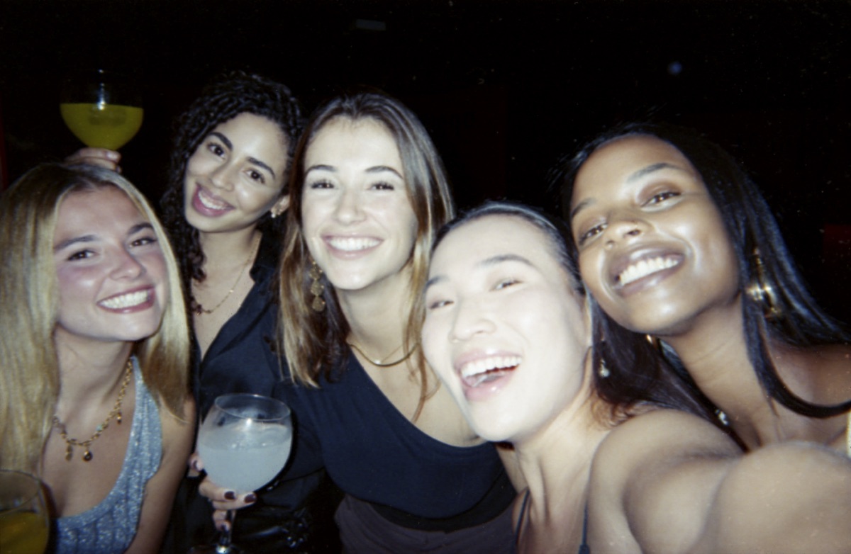 Five friends raising cocktails for a selfie inside a cocktail bar in Escalón, San Salvador